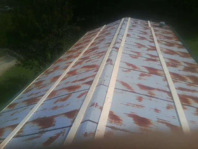Rusted metal roof panels with new wood purlins before replacement — Storm Damage Roof Repair in Enterprise by Roofing Brothers